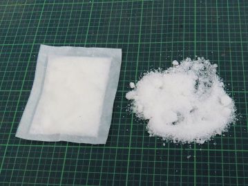 樟脳の白色結晶（右）。徐々に揮発し、防虫効果が得られる。通常は左のように紙や布に包んだ状態で使用。