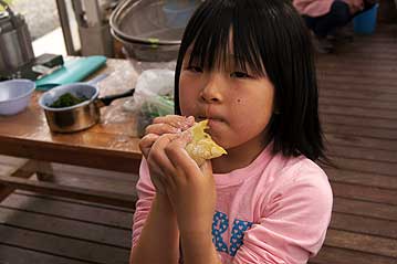 自分で丸めた、できたてのお餅をぱくり。臼と杵でついたお餅はよく伸びて、「おいしい！」の声。