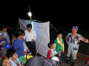 講師の岡本忠 倉敷昆虫館館長の解説に耳を傾ける子供たち。光に集まる虫と、集まらない虫がいるとのこと。