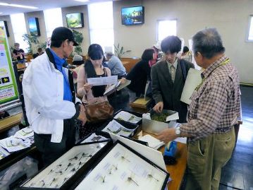 カワラケツメイのお茶の楽しみ方と、野草のタネの育て方を説明する植物園のボランティアさん（手前2人）。植物園での活動を通じて日頃接している植物ですので、解説はお手の物？