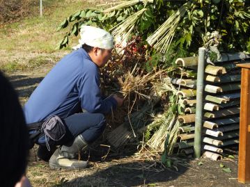 火口をカヤネズミの巣に移し、さらに乾いた草でくるむようにして、ふーっと息を吹きかけます。