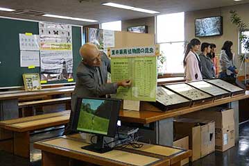 昆虫館コーナーを準備中の岡本館長。植物園がアナログ（豆鉄砲）なのに対し、パソコンでスライドショーを流すなど、デジタルを有効に使われていたようです。