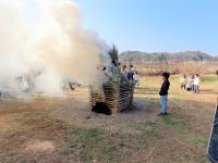 園長による火打石での着火直後、煙を出して燃えるとんどのやぐら。とんど焼きの煙を浴びると風邪をひかないとか。